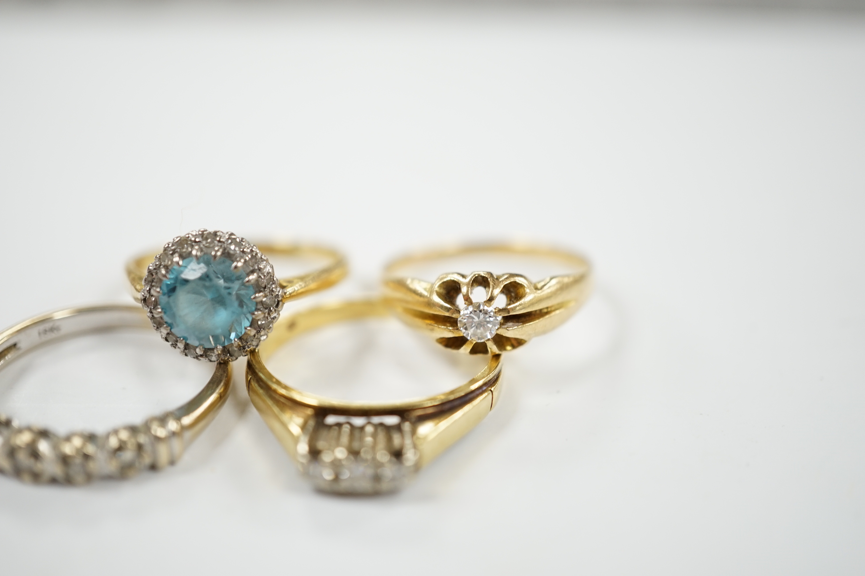 Three assorted 18ct and gem set dress rings, including blue zircon and diamond chip and claw set solitaire and one other yellow metal and gem set ring, gross weight 12.6 grams.